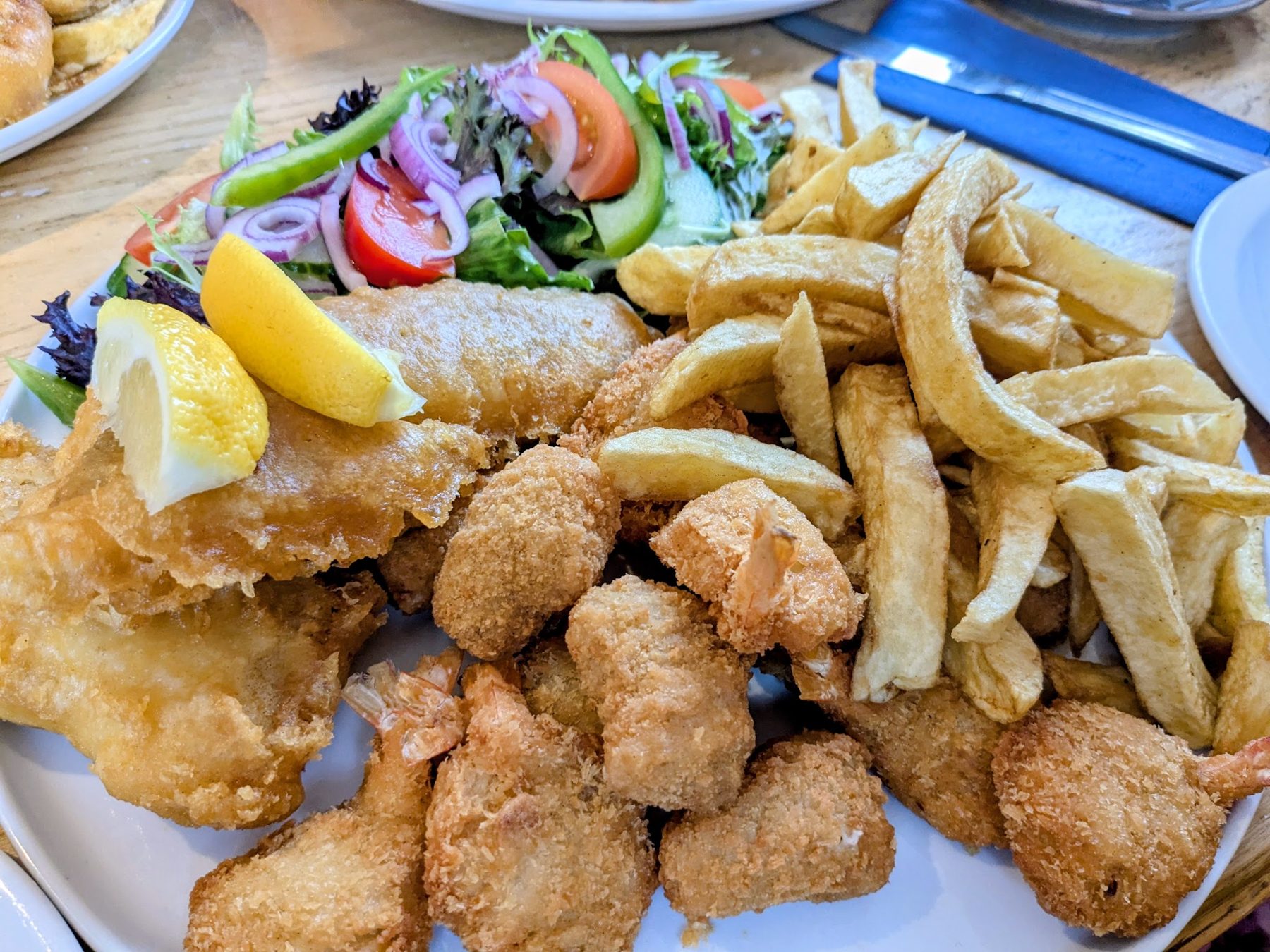 Battered fish, scampi and chips with a side salad and lemon